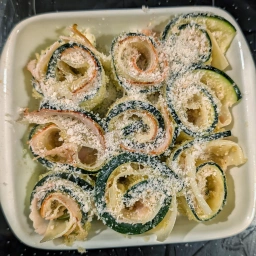 Place zucchini rolls into a baking dish