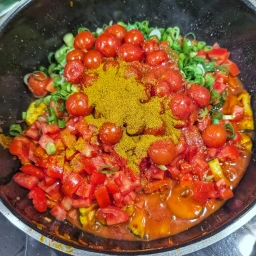 Add the spring onions, tomatoes and Ras el Hanout