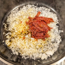 Zwiebeln, Knoblauch und Tomatenmark anschwitzen