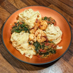 Pasta mit Garnelen, Parmesan-Sauce und Spinat mit getrockneten Tomaten
