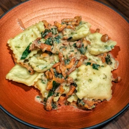 Finished dish: Ravioli with spinach-ricotta filling and fried chanterelles in a white wine and Grana Padano sauce