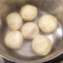 Adding Marillenknödel to the salted water