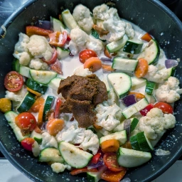 Alle Zutaten mit Kokosmilch und roter Currypaste